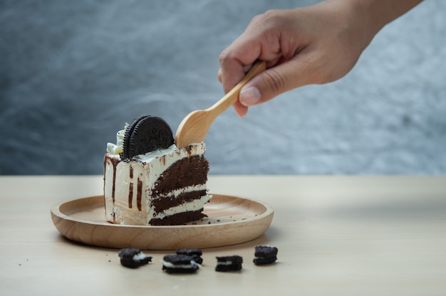 Snijd cakestuk met houten lepel op houten presenteerblad