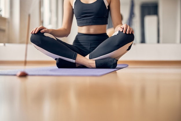 Snijd de foto van een slanke vrouw af terwijl ze yoga doet met een aromastick