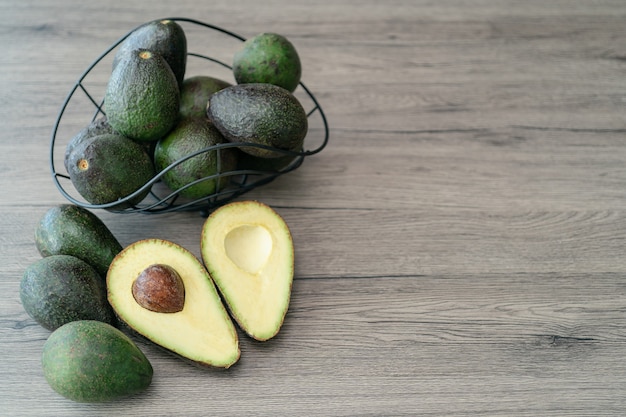 Snijd de helft, gesneden verse groene avocado op bruine houten tafel. Vruchten gezond voedsel concept.