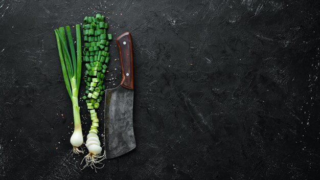 Snijd groene uien op een houten tafel Verse groenten Bovenaanzicht Vrije ruimte voor tekst