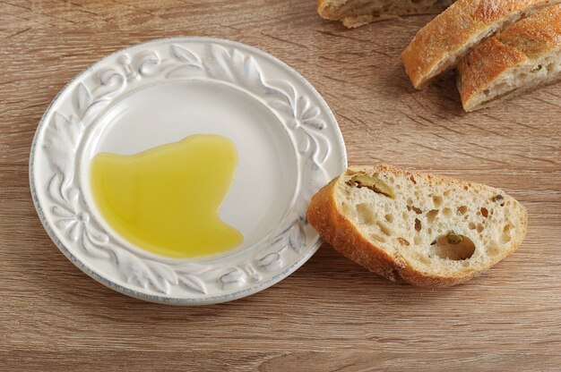 Snijd in stukjes ciabatta met olijven en olijfolie in een schotel