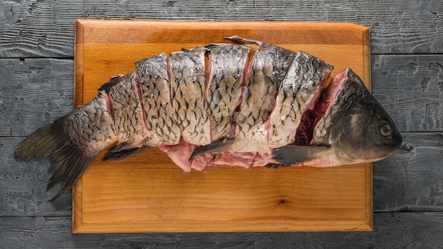 Snijd karper vissen in stukken met op een zwarte tafel