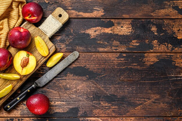 Snijd nectarines op een houten snijplank.