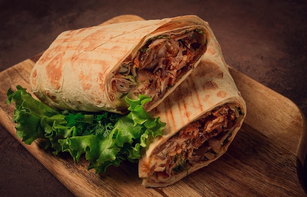Snijd shawarma 2 stukken op een snijplank close-up