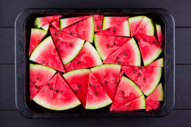 Snijden watermeloen op donkere planken gesneden watermelon in vintage bakplaat Rode watermelon