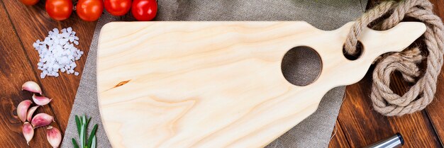 Snijplank met een mes op een donkere houten tafel