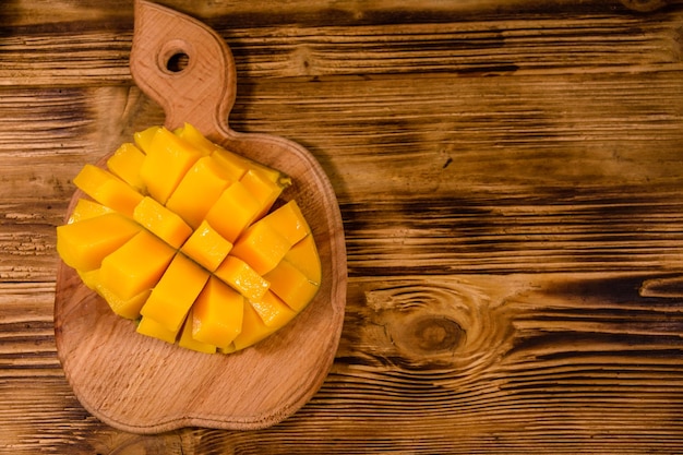 Snijplank met gehakte mangofruit op een houten tafel Bovenaanzicht