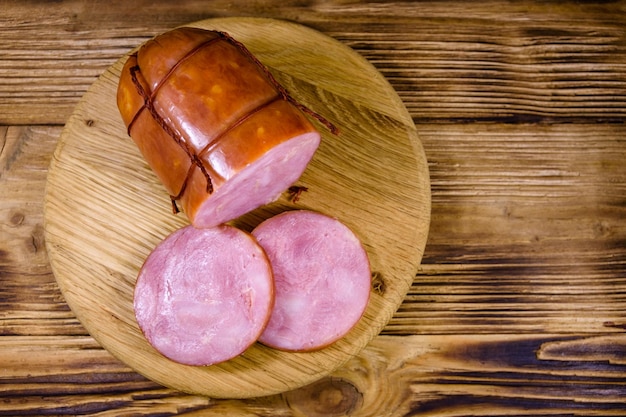 Snijplank met gesneden worst op rustieke houten tafel Bovenaanzicht