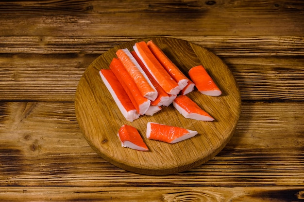 Snijplank met stapel krabstokken op een houten tafel