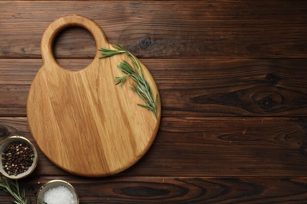 Snijplank zout peper en rozemarijn op houten tafel plat leg ruimte voor tekst