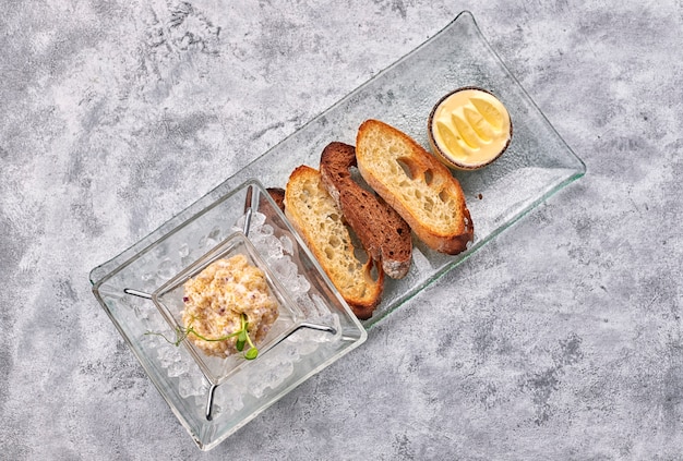 Snoekviskaviaar, op ijs, met croutons en boter, op een transparante schaal, op een witte achtergrond