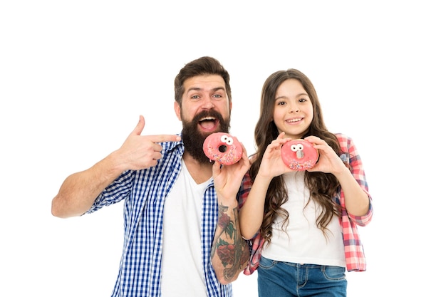 Snoep en lekkernijen concept Dochter en vader eten zoete donuts Geluk en vreugde Hongerig kind Bakkerij Vaderdag Zoete tand Meisje kind en vader houden geglazuurde donuts Vrolijke familie