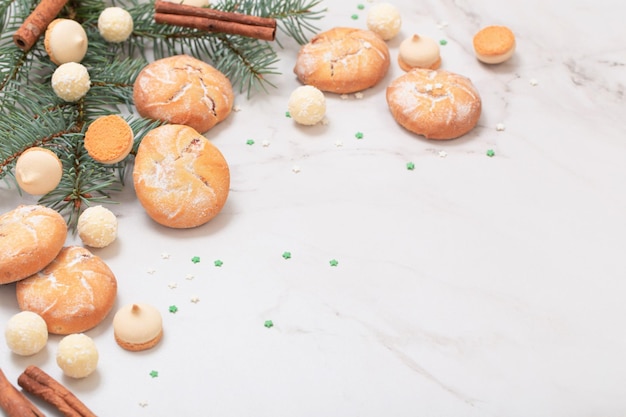 Snoepjes en koekjes met kerstboomtakken op witte marmeren achtergrond