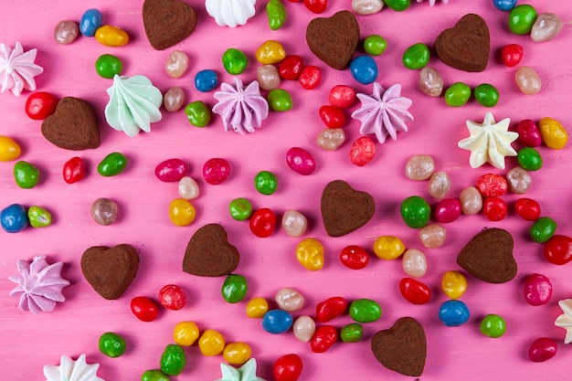 Snoepjes op een roze tafel. Valentijnsdag. Hartvormige snoepjes.