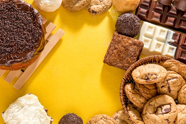 Snoepjes op tafel. Chocoladetaart, koekjes, brownie en chocoladereep. Bovenaanzicht.