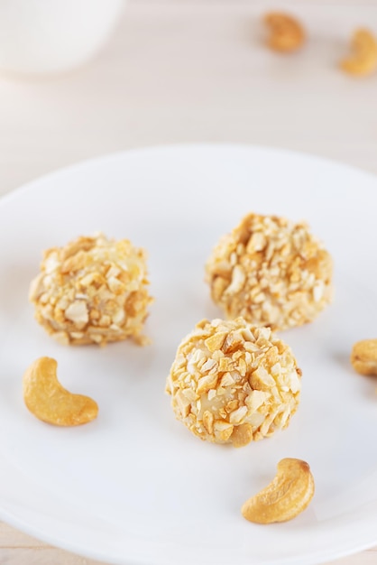 Snoeptruffels brigadeiro met cashewnoten op een wit bord op tafel