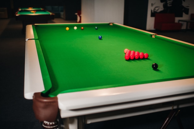 Snookerballen op een groene biljarttafel plaatsen.