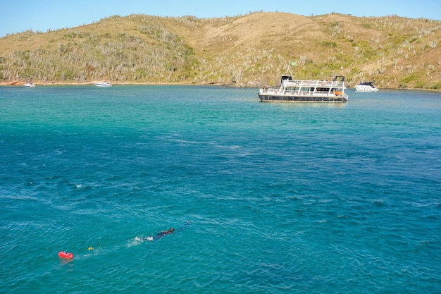 Snorkelaar zwemt op het oppervlak van de oceaan met behulp van een boei