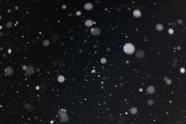 黒の背景に雪オーバーレイ雪の背景の雪片