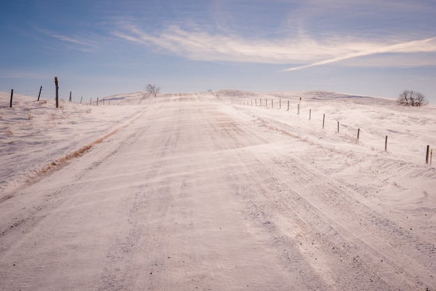 Snow blowing over gravel road in a Saskatchewan winter