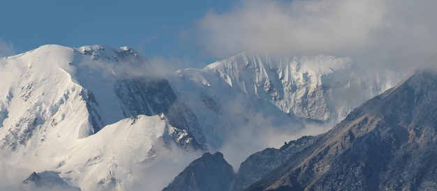 Snow capped mountain peaks in the clouds