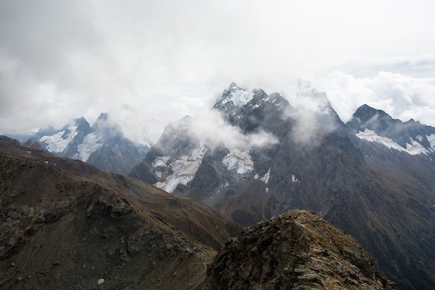 Snow capped mountain range in the clouds. Caucasus, Russia