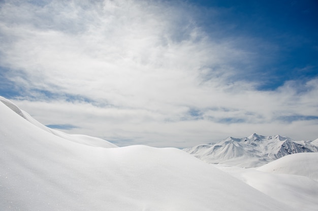 積雪と雪に覆われた山々の頂上、青空