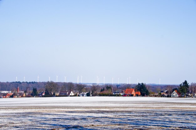 Snow covered field against clear sky