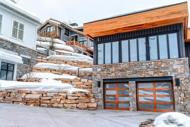 Snow covered house by building against sky