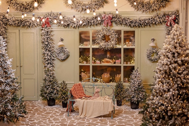 The snow-covered house is decorated for the new year. Vintage winter courtyard, decorated with Christmas trees, lanterns and a cozy bench and shop window with fresh pastries. Soft selective focus.