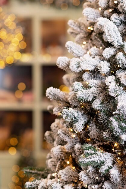 雪に覆われた家は新年のために装飾されています。クリスマスツリー、ランタン、焼きたてのペストリーのショーウィンドウで飾られたヴィンテージの冬の中庭。ソフトセレクティブフォーカス。