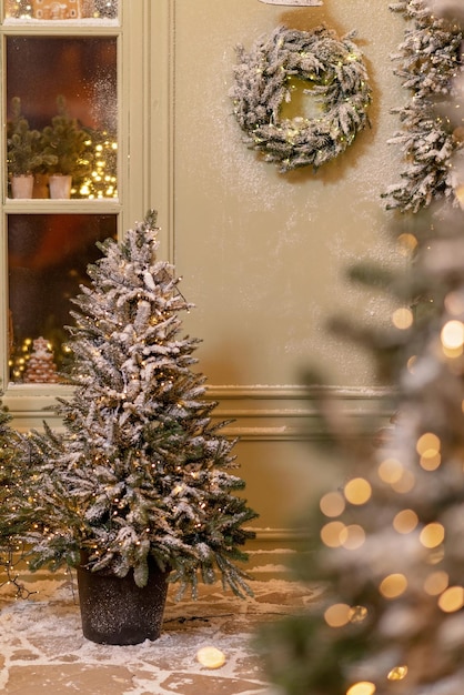 The snow-covered house is decorated for the new year. Vintage winter courtyard, decorated with New Year's decorations, Christmas trees, lanterns lights. Soft selective focus.