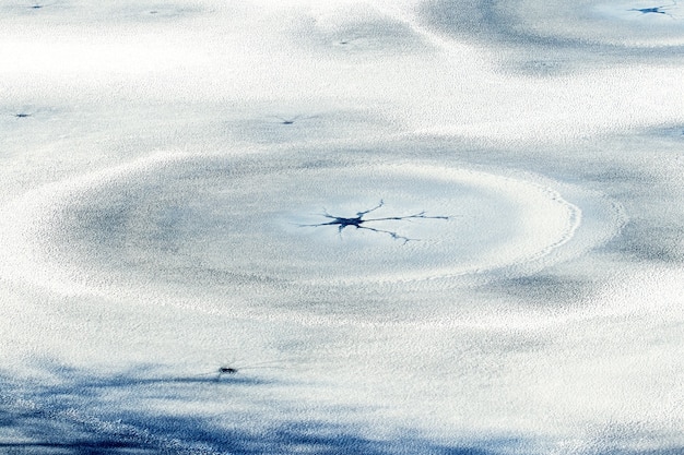 Snow-covered ice with cracks and concentric circles