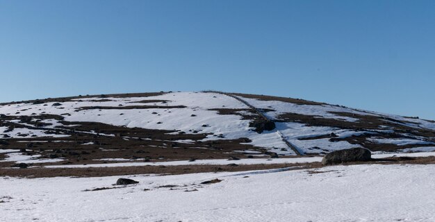 Foto paesaggio coperto di neve contro un cielo blu limpido