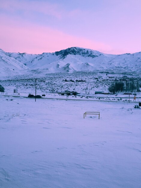 写真 夕暮れの空に照らされた雪に覆われた風景