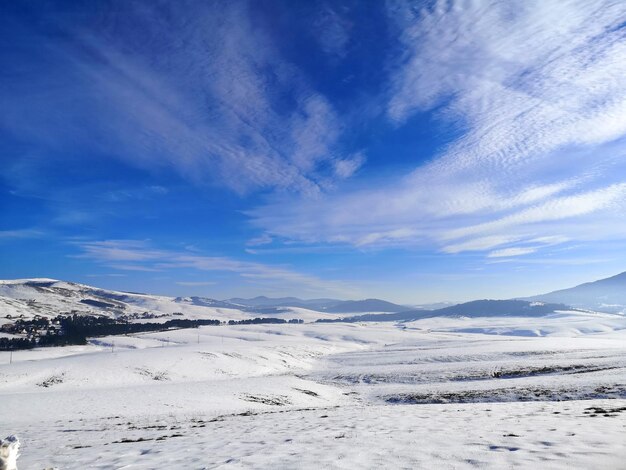 Snow covered landscape against sky