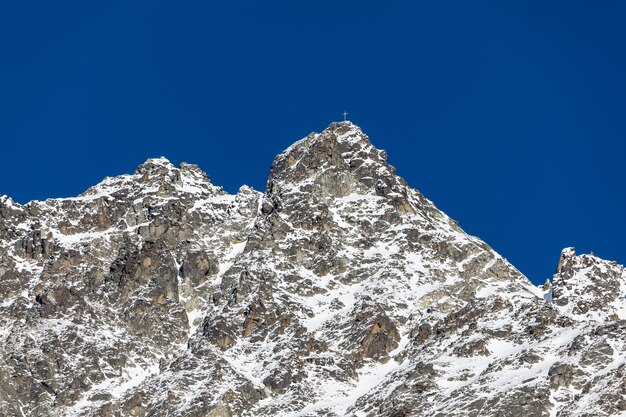 Snow covered mountain peak against clear blue sky