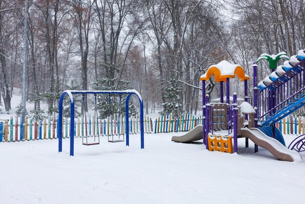 Снежная игровая площадка в городском парке в зимний день