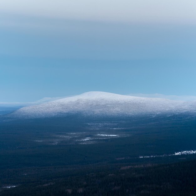 Snow-covered polar cone hill in winter early in the morning.\
winter polaris landscape. view of the snow-covered tundra and\
hills. cold winter weather. harsh northern climate. square\
view.