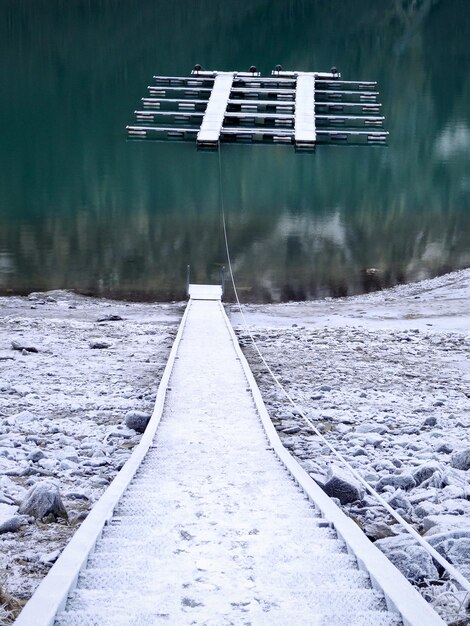 Foto tracce ferroviarie coperte di neve vicino al lago durante l'inverno