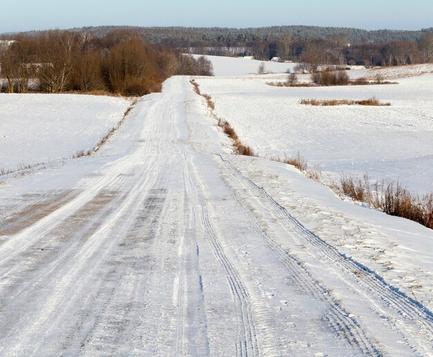 Foto strada innevata dopo l'ultima nevicata. carreggiata di piccole dimensioni. primo piano in inverno.