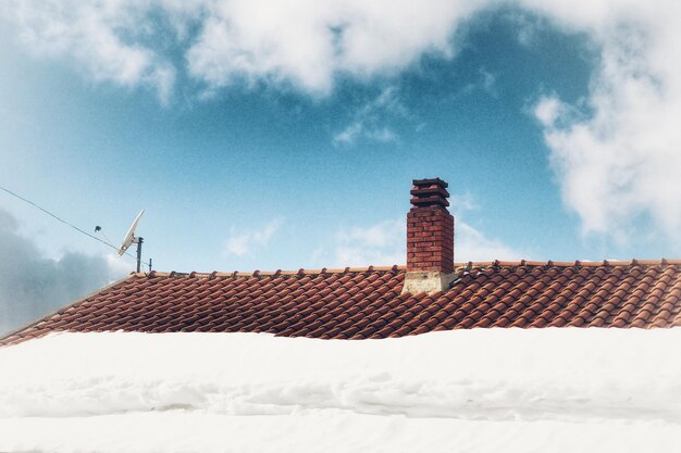 Photo snow covered roof and building against sky