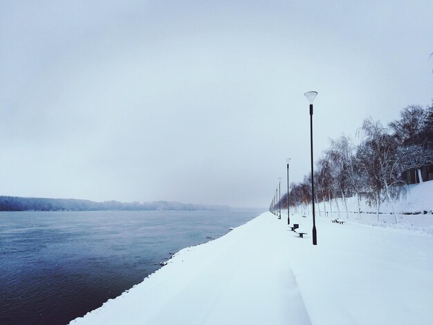 Snow covered street against sky