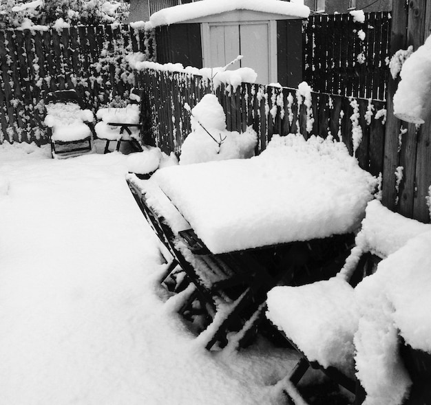 Foto tavoli e sedie coperti di neve nel cortile sul retro