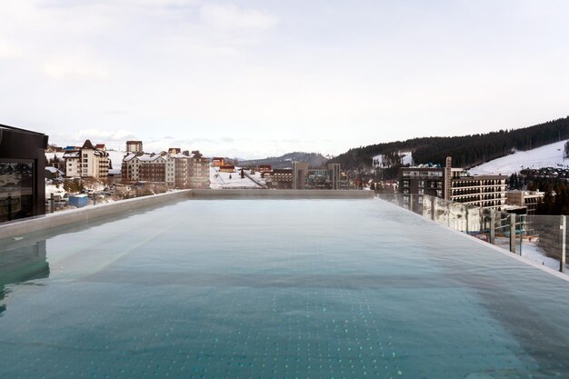 Snow falling on pool at the winter mountains winter resort with
swimming pool mountains at the background stock photo