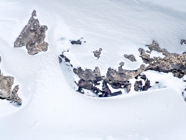 Snow field with white mountains under cloudy sky in Iceland