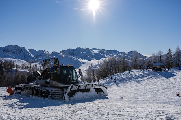 Snow groomer ramming a ski track in Alps