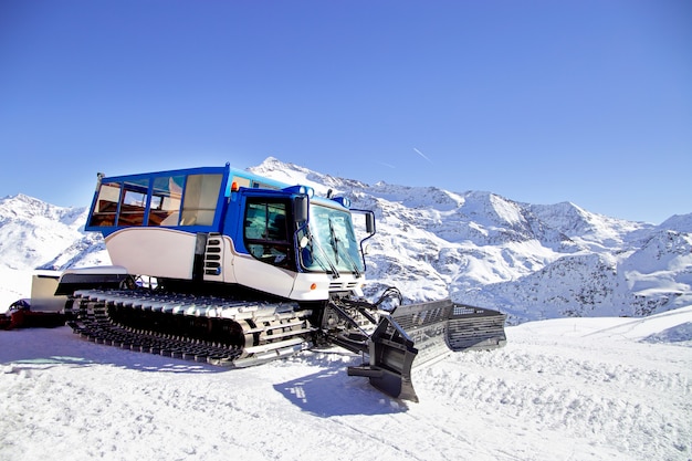 Snow grooming machine on snow hill ready for skiing slope preparations in alps, europe ski resort