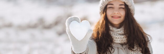 女性の手に雪の心