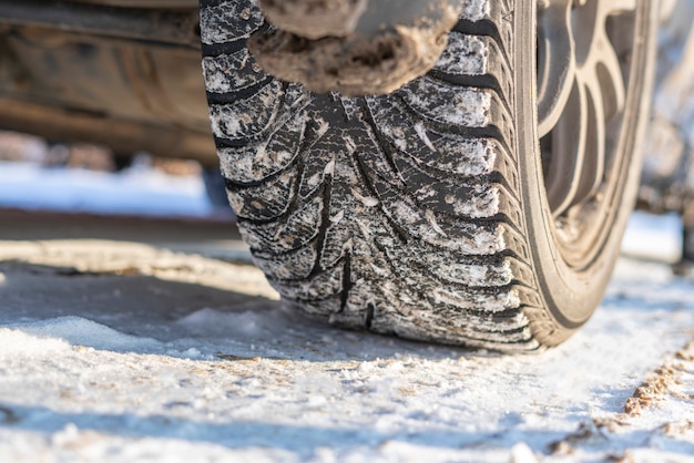 A snow and ice winter car tyres close up auto vehicle wheel